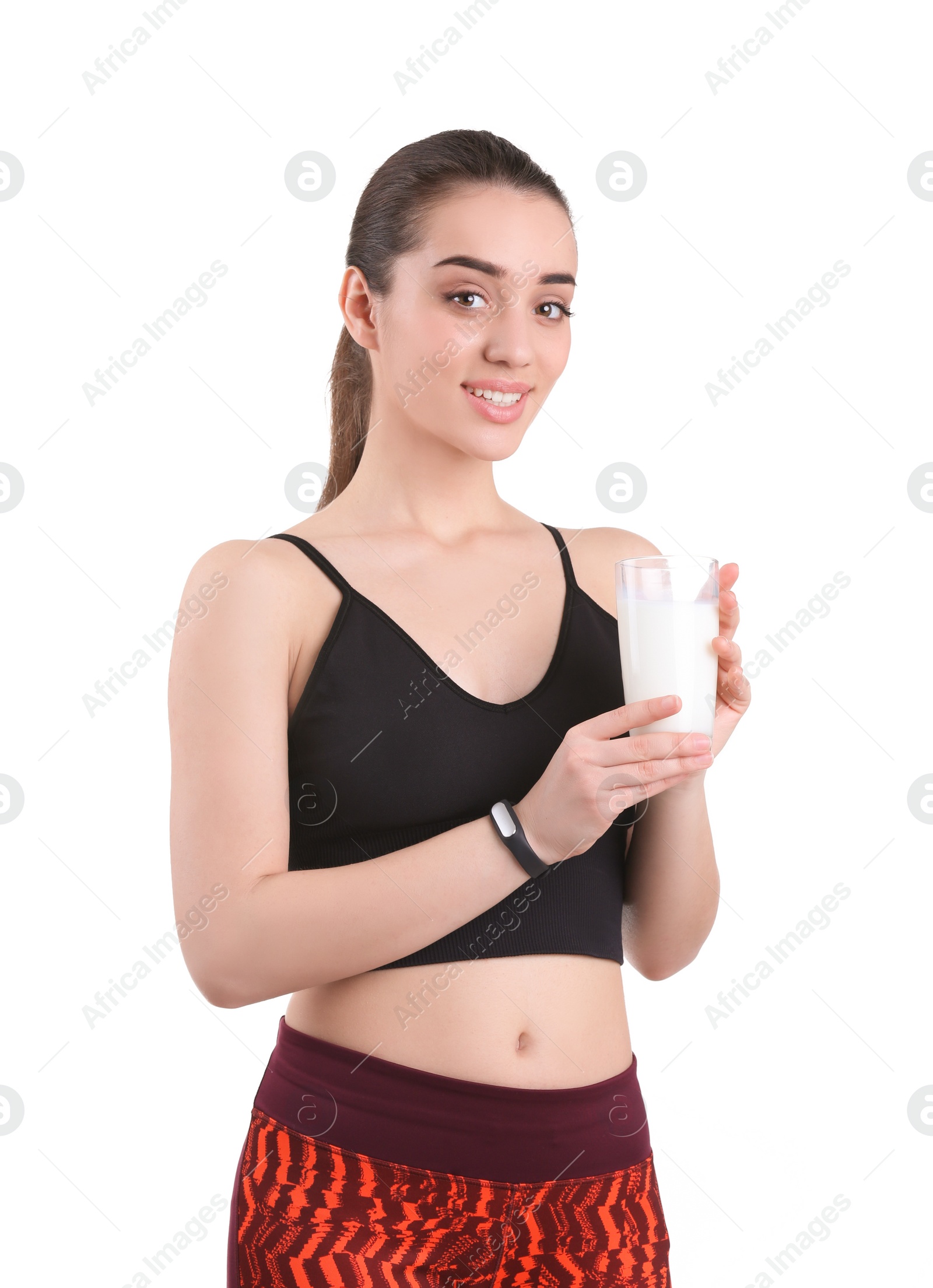 Photo of Beautiful young woman in sportswear drinking milk on white background