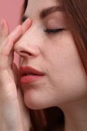 Photo of Portrait of beautiful woman with freckles on pink background, closeup