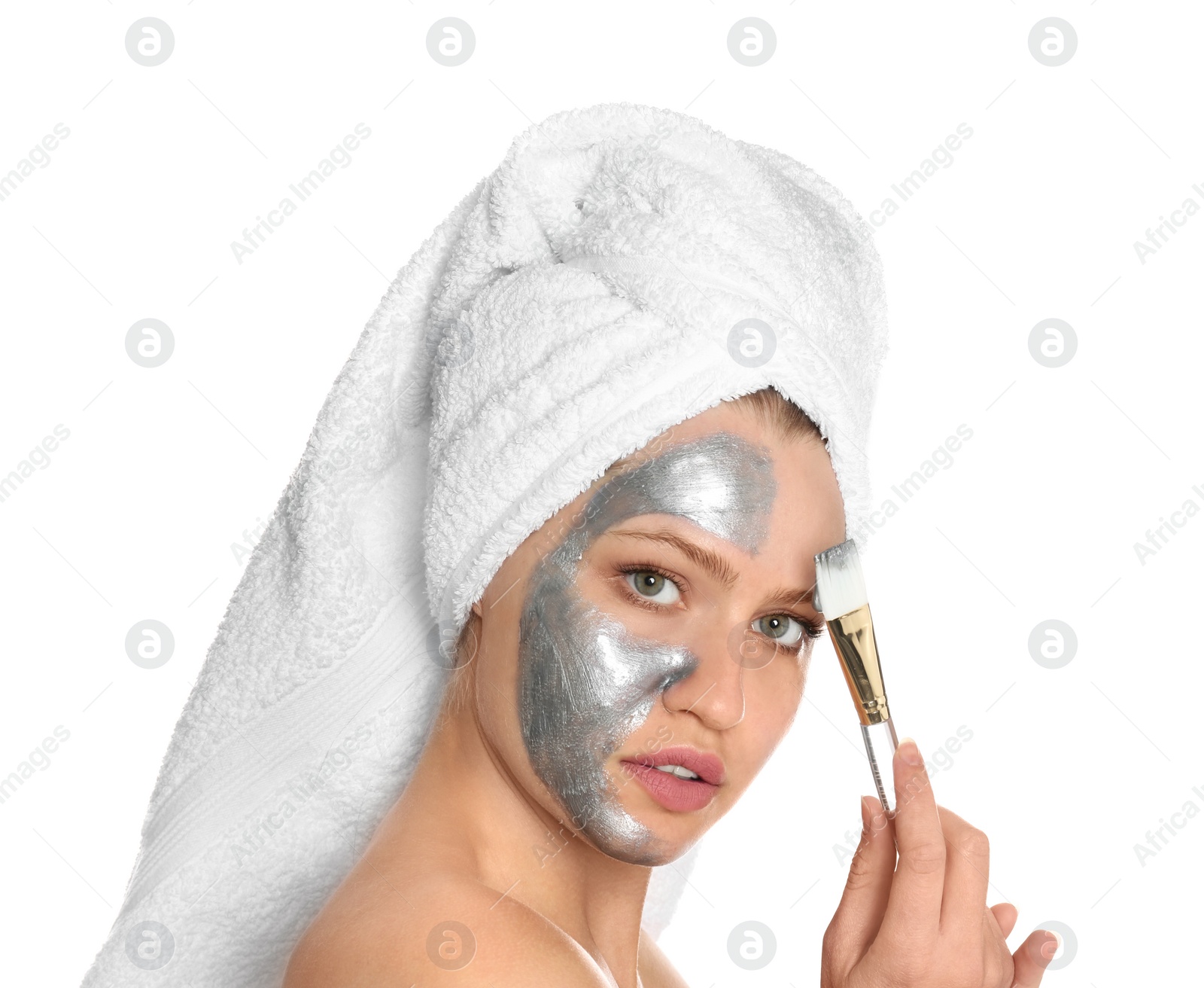 Photo of Beautiful woman applying silver mask on her face against white background