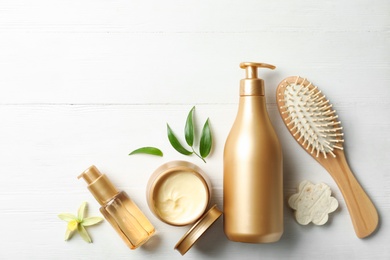 Photo of Flat lay composition with hair cosmetic products on white wooden table