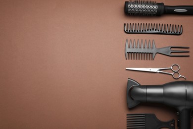Flat lay composition of professional hairdresser tools on brown background, space for text
