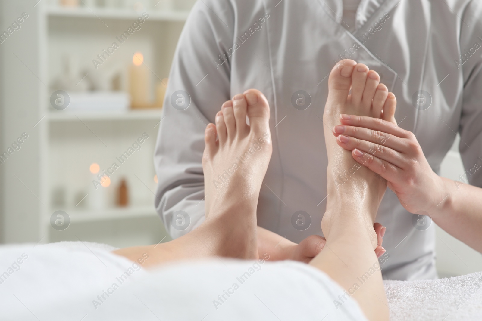 Photo of Woman receiving foot massage in spa salon, closeup