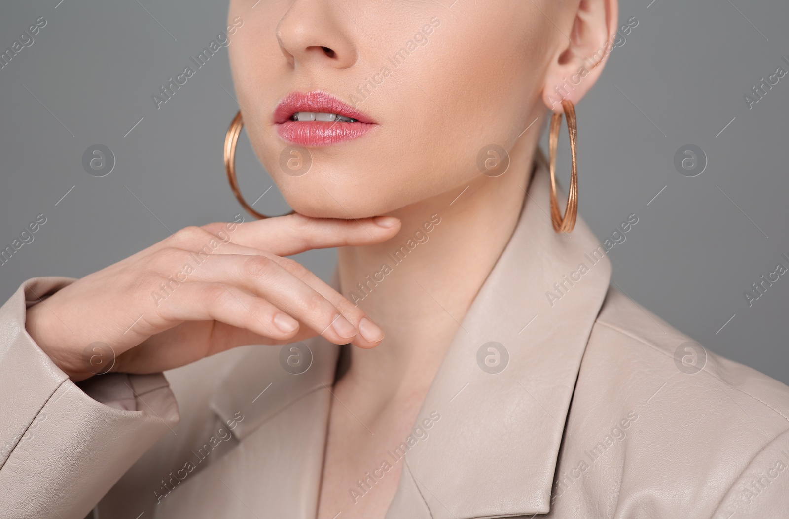 Photo of Woman with elegant earrings on gray background, closeup