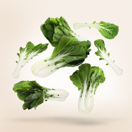 Image of Fresh green pak choy cabbages falling on light background