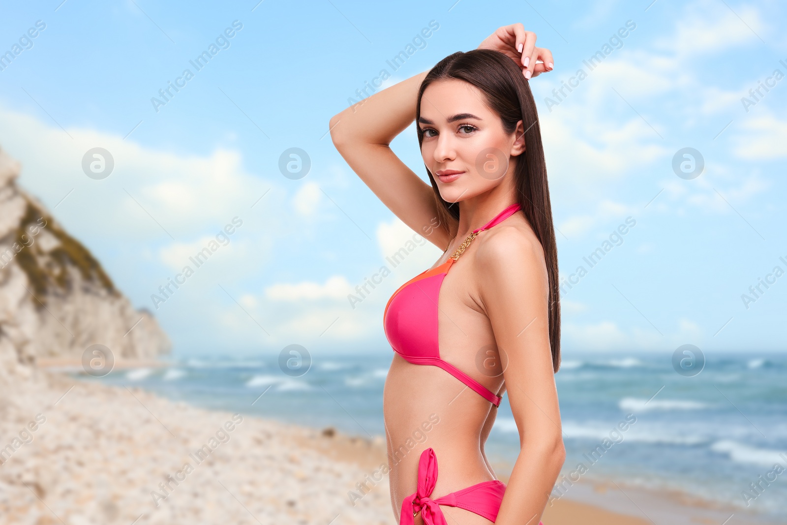 Image of Beautiful woman in stylish pink bikini on sandy beach near sea, space for text