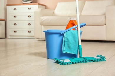 Cleaning supplies on floor in living room. Space for text