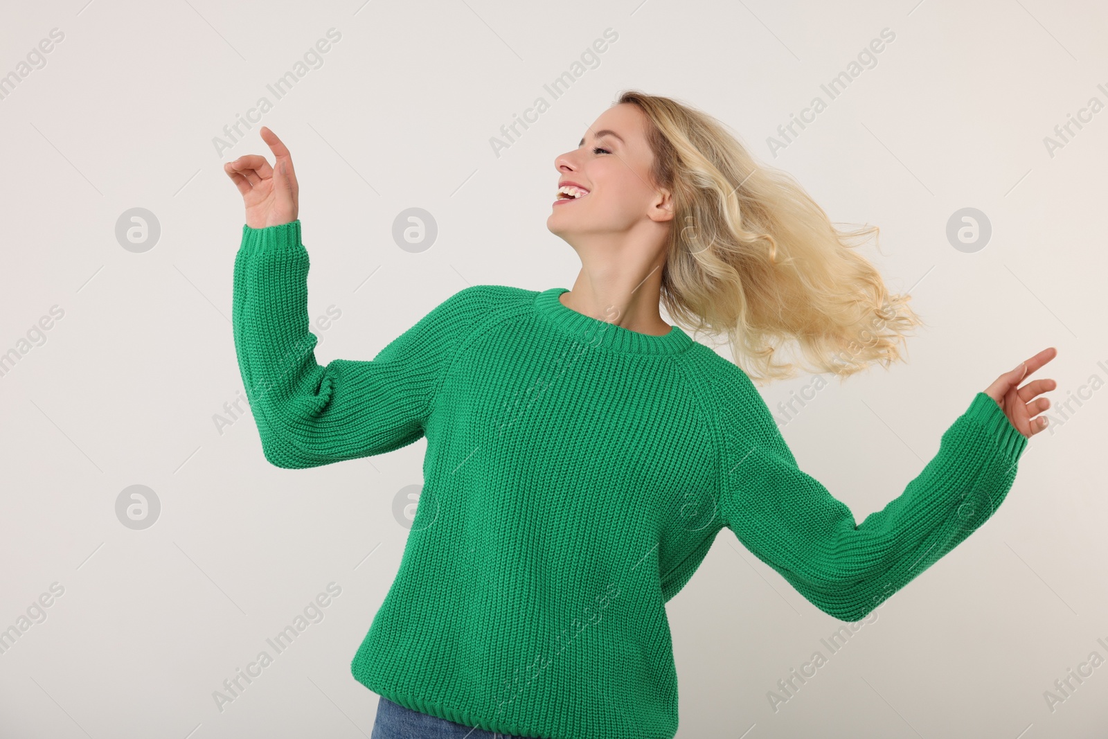 Photo of Happy woman in stylish warm sweater on white background