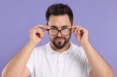 Photo of Handsome man wearing glasses on violet background
