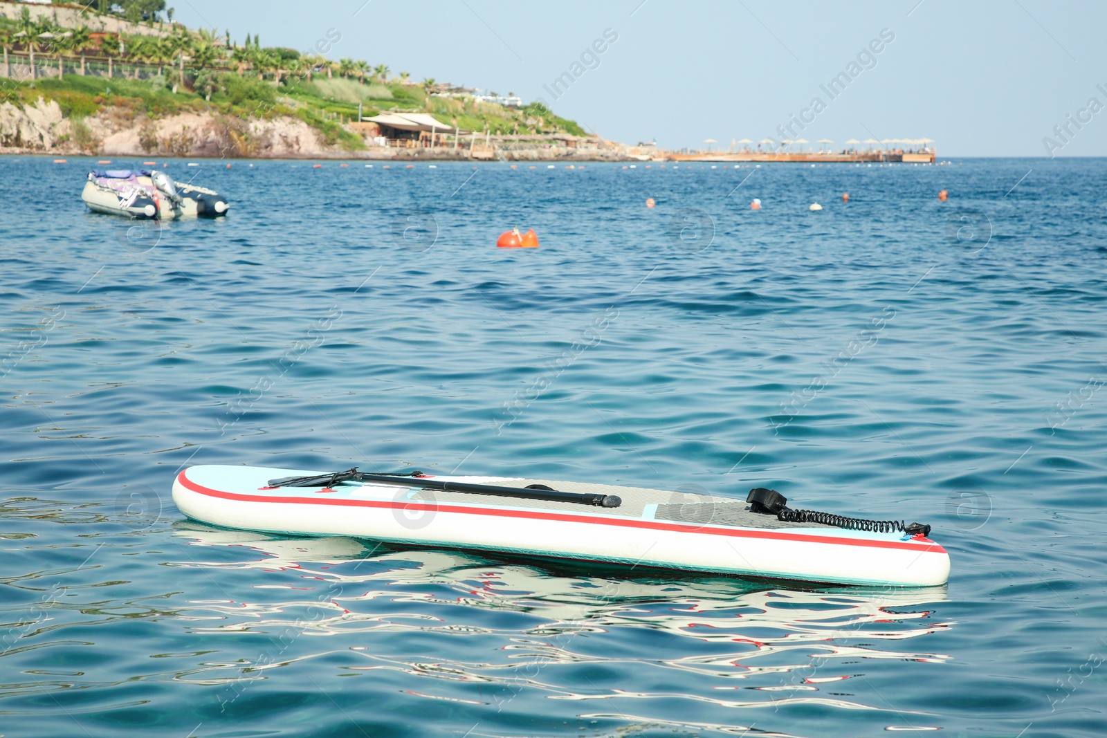 Photo of One SUP board with paddle on sea water