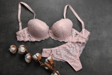 Elegant light pink women's underwear and cotton flowers on grey background, flat lay