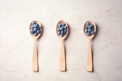 Photo of Flat lay composition with spoons and juicy blueberries on color table