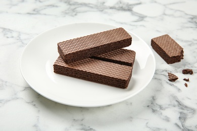 Photo of Plate of delicious chocolate wafers on marble background