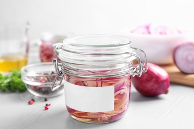 Photo of Jar of pickled onions with blank label on light table