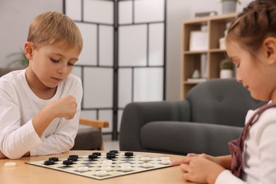 Photo of Children playing checkers at coffee table in room