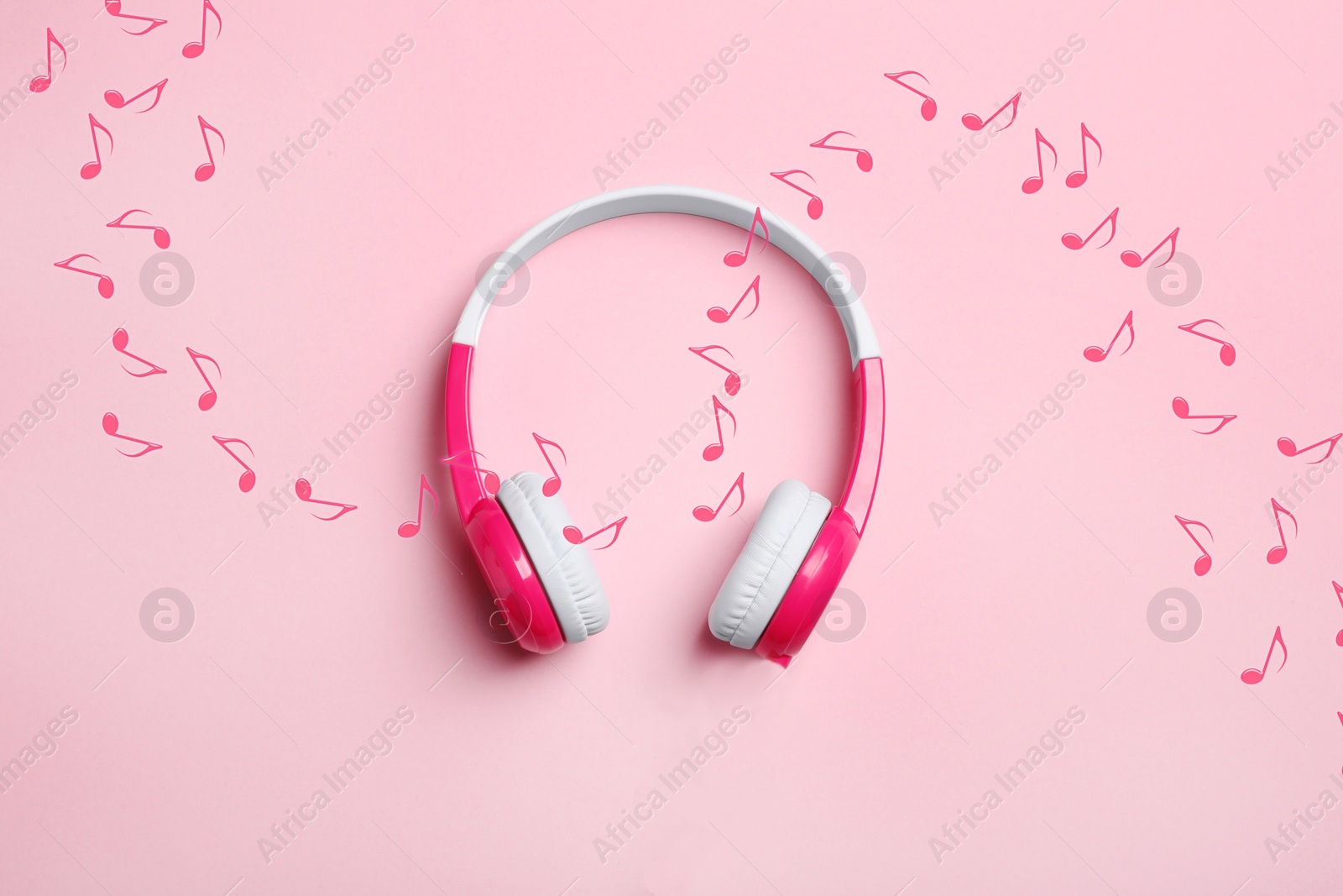 Image of Music notes flowing from headphones on pink background, top view