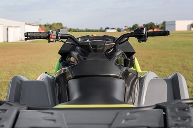 Modern quad bike in field on sunny day, closeup