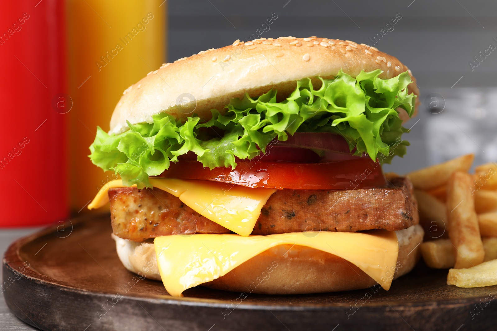 Photo of Delicious tofu burger served with french fries on board, closeup