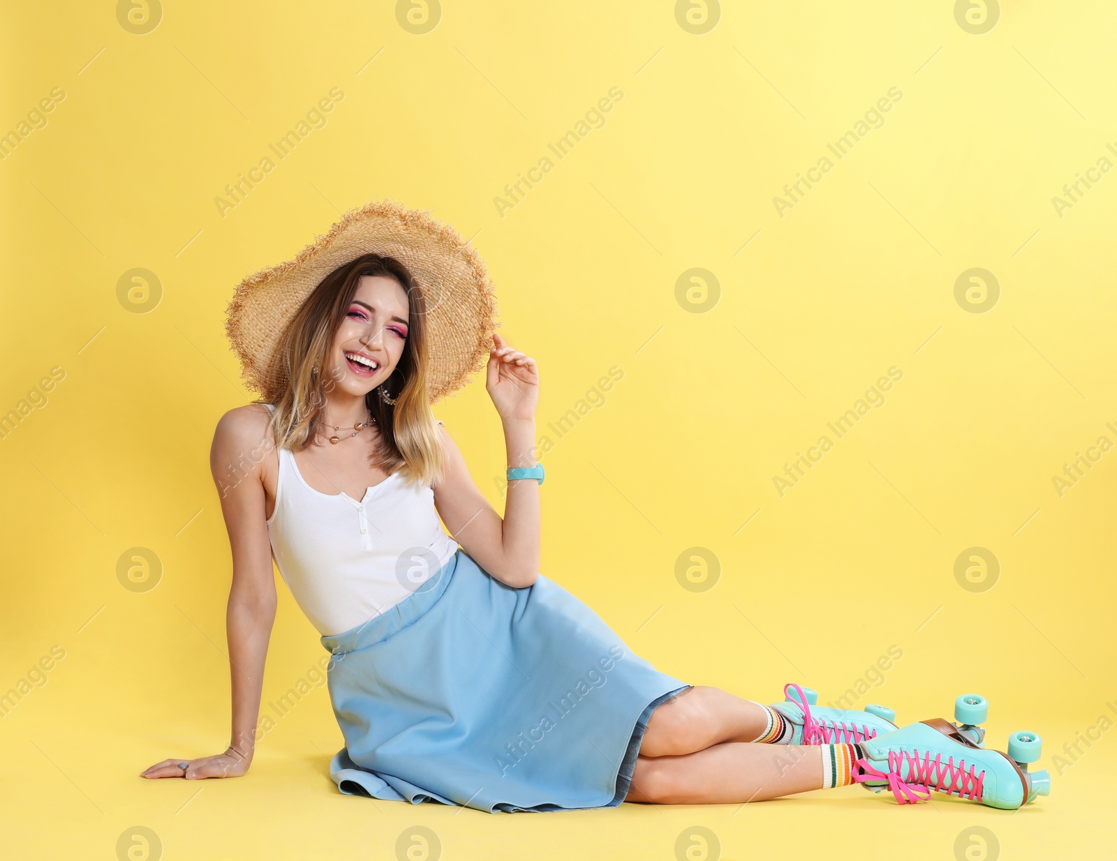 Photo of Young woman with retro roller skates on color background