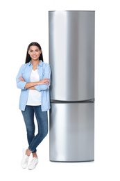 Photo of Young woman near closed refrigerator on white background