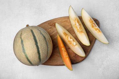 Tasty colorful ripe melons on light grey table, top view