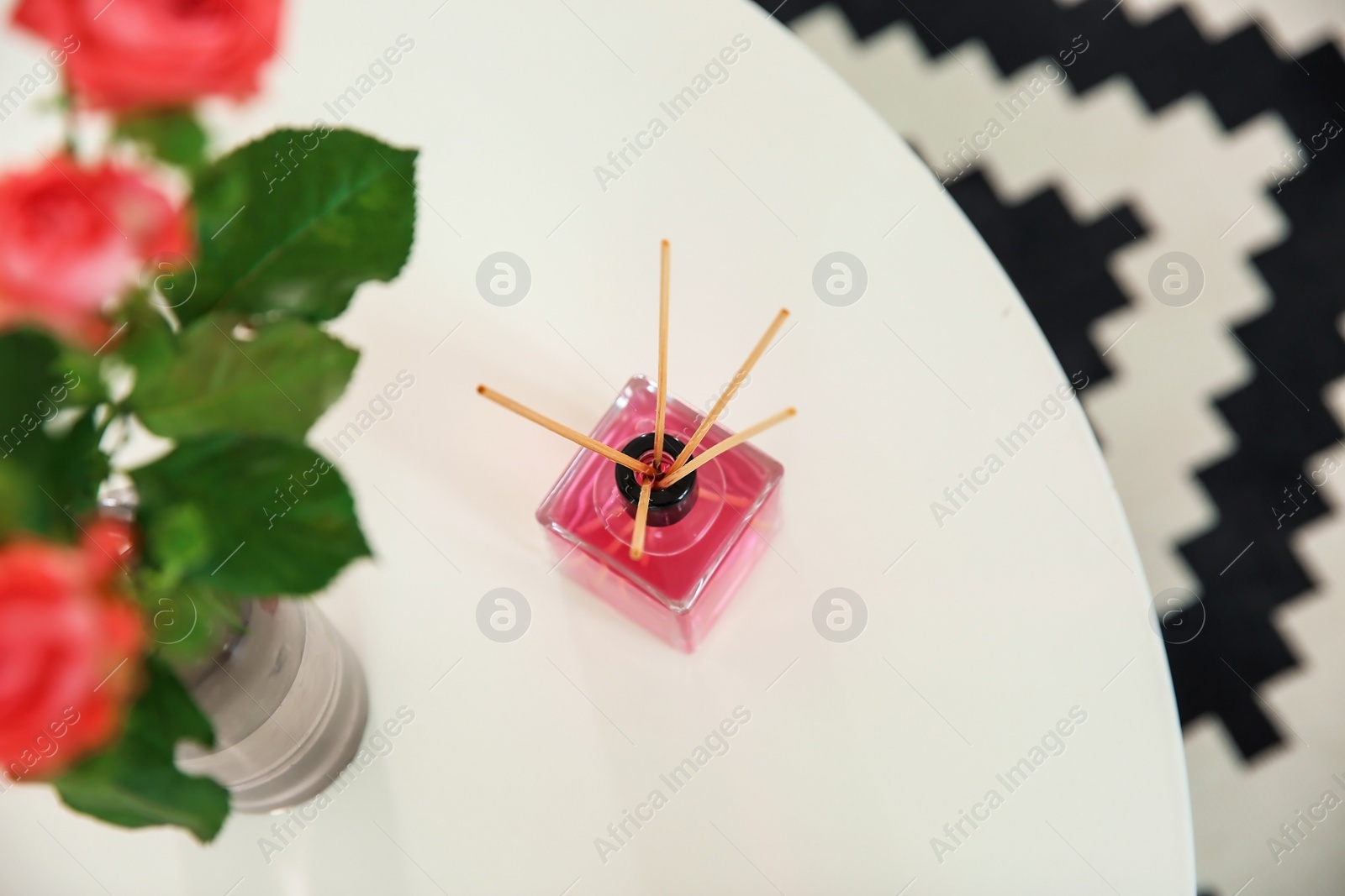 Photo of Aromatic reed air freshener on table indoors