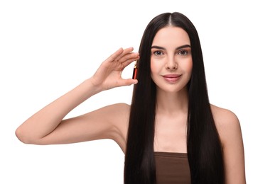 Photo of Beautiful young woman holding skincare ampoule on white background