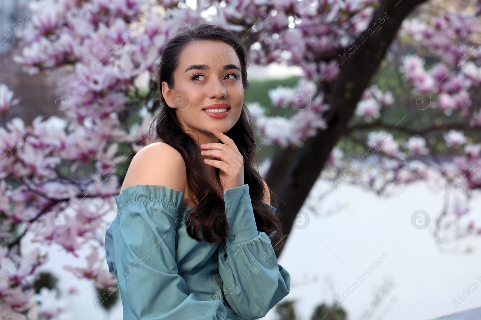 Photo of Beautiful woman near blossoming magnolia tree on spring day