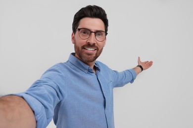 Smiling man taking selfie on white background