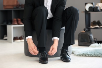 Photo of Young man trying on shoes in store