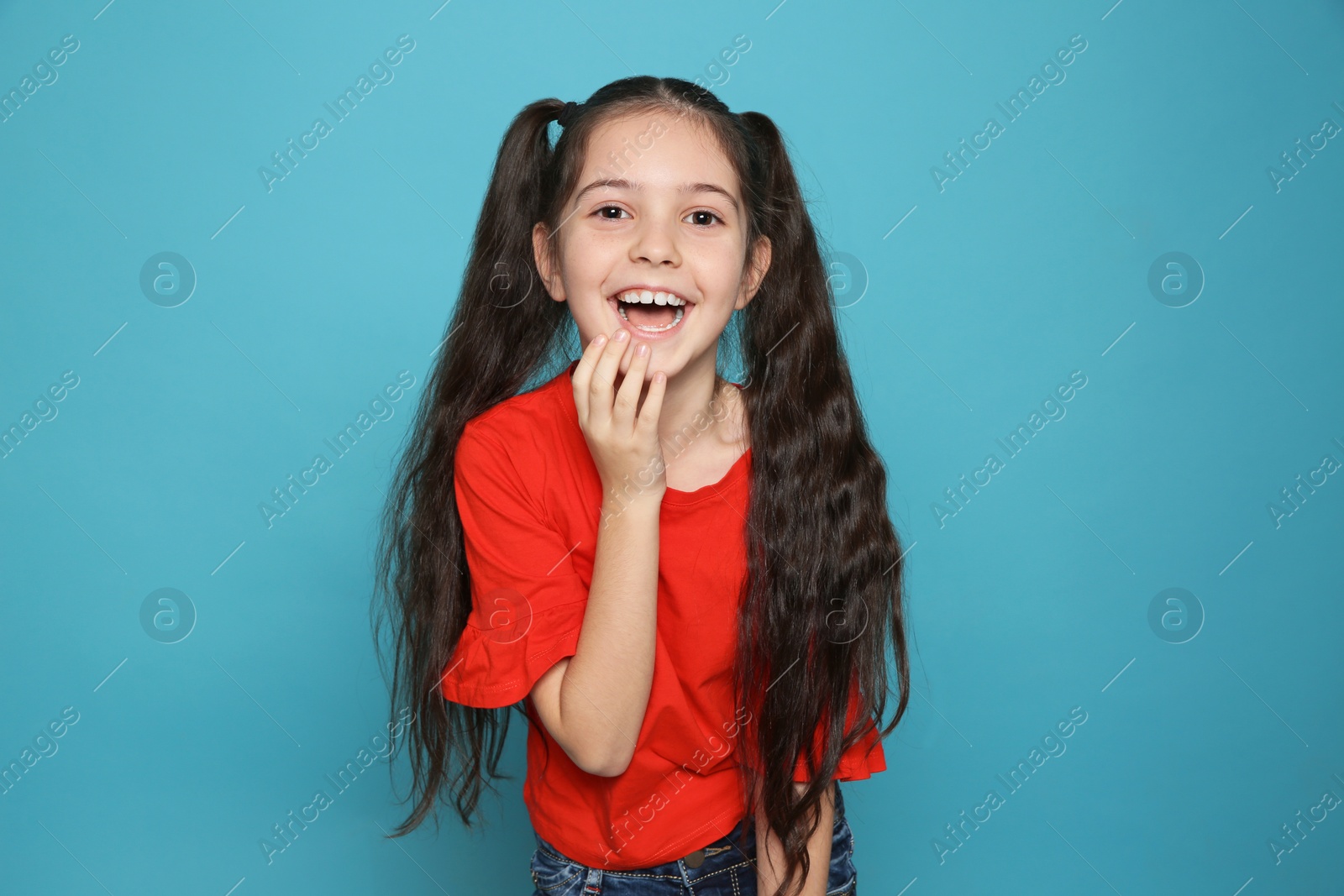 Photo of Portrait of little girl laughing on color background