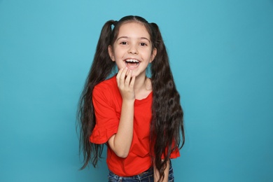 Photo of Portrait of little girl laughing on color background