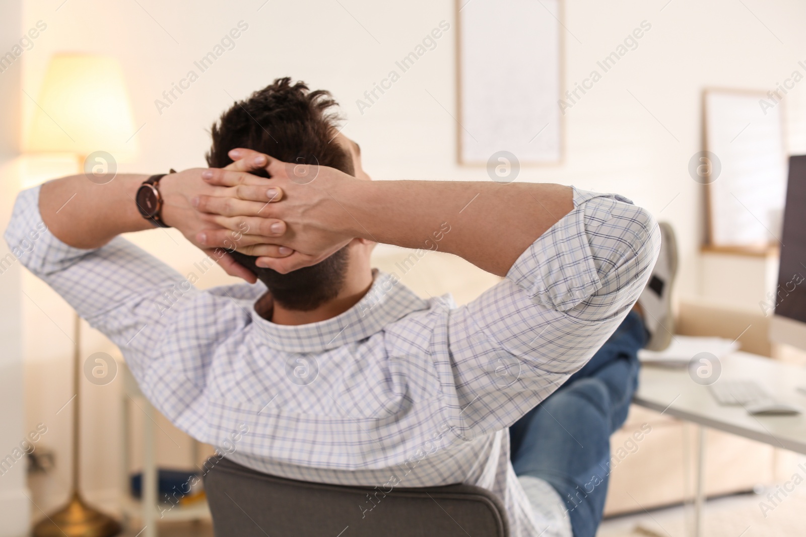 Photo of Young man relaxing at table in office during break