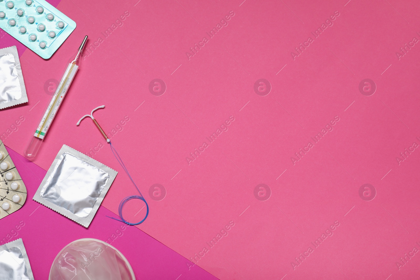 Photo of Contraceptive pills, condoms, intrauterine device and thermometer on color background, flat lay and space for text. Different birth control methods