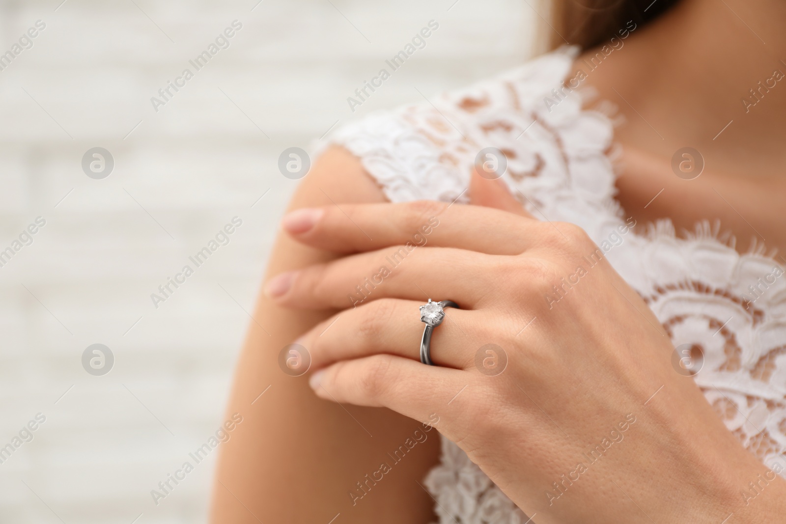 Photo of Young bride wearing beautiful engagement ring, closeup