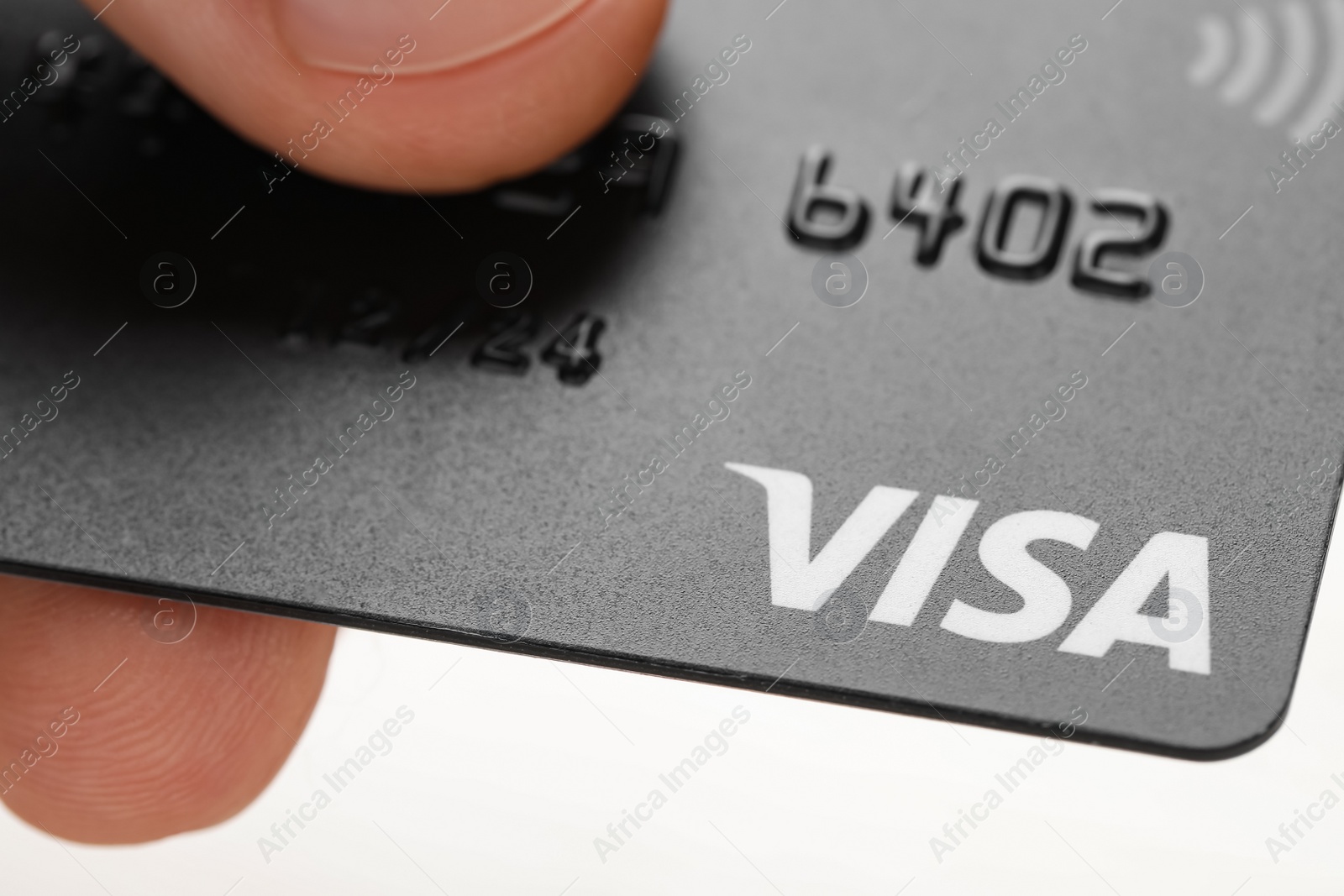 Photo of MYKOLAIV, UKRAINE - FEBRUARY 22, 2022: Woman holding Visa credit card on white background, closeup