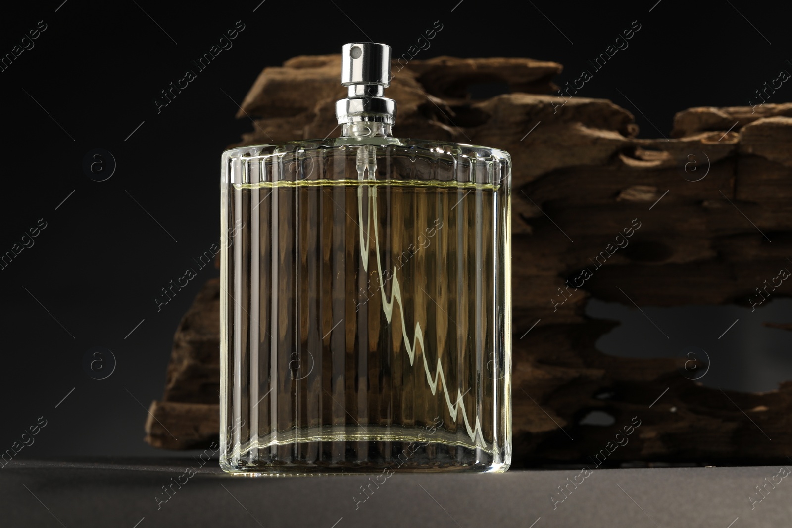 Photo of Luxury men`s perfume in bottle on grey table
