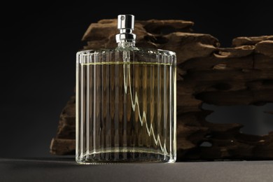 Photo of Luxury men`s perfume in bottle on grey table