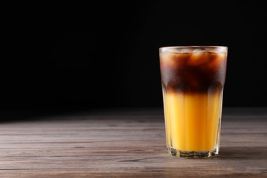 Photo of Tasty refreshing drink with coffee and orange juice on wooden table, space for text