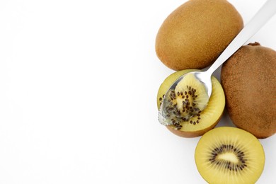 Photo of Fresh ripe yellow kiwis with spoon on white background, top view