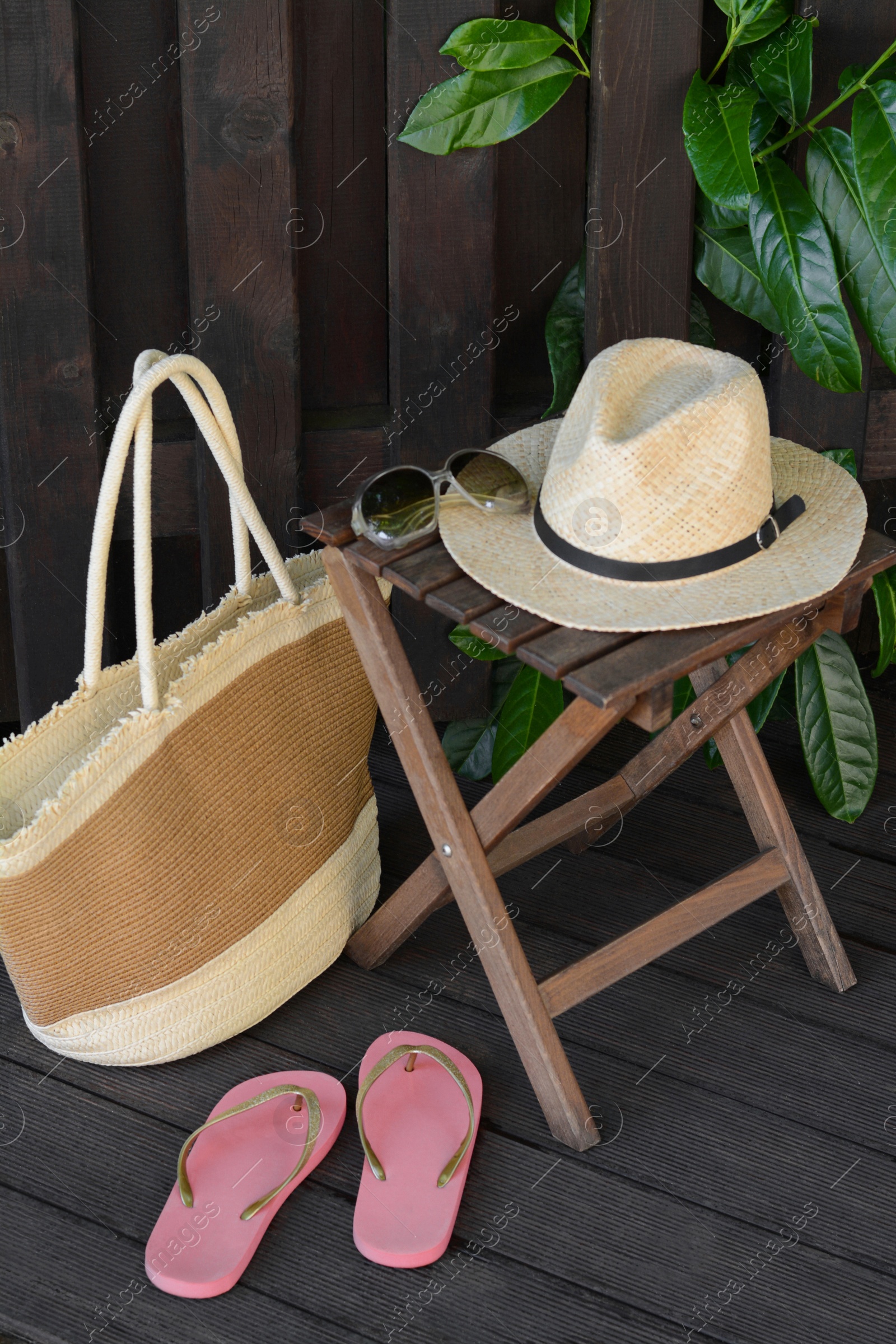 Photo of Different stylish beach accessories near wooden fence