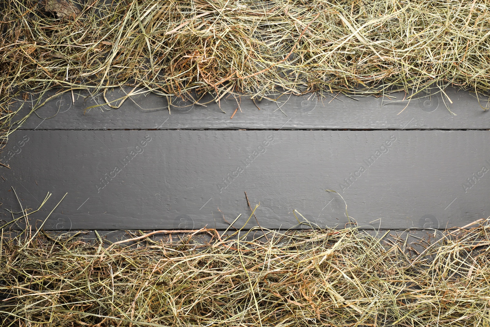 Photo of Frame made of dried hay on grey wooden table, top view. Space for text