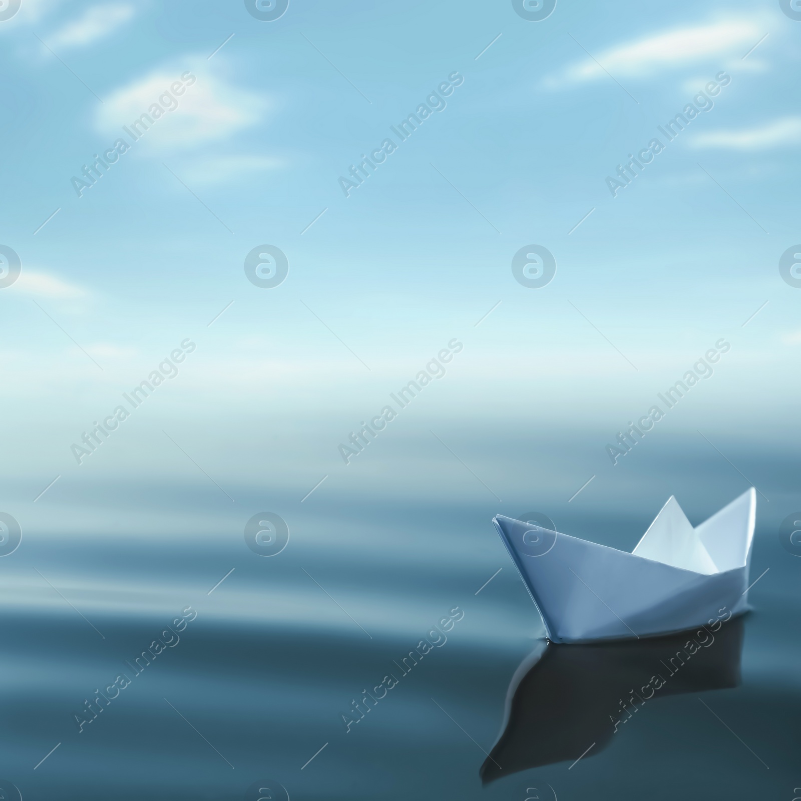 Image of White paper boat floating on calm sea. Space for text