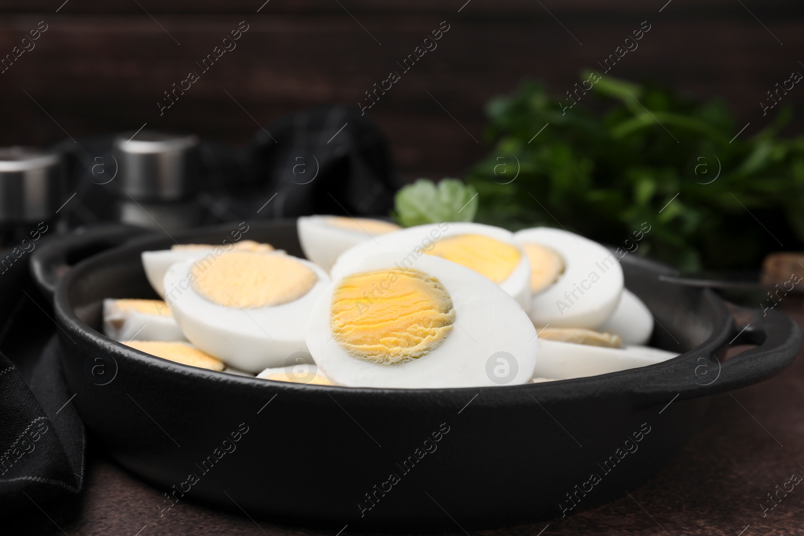 Photo of Fresh hard boiled eggs and parsley on brown table, closeup