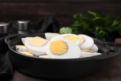 Fresh hard boiled eggs and parsley on brown table, closeup