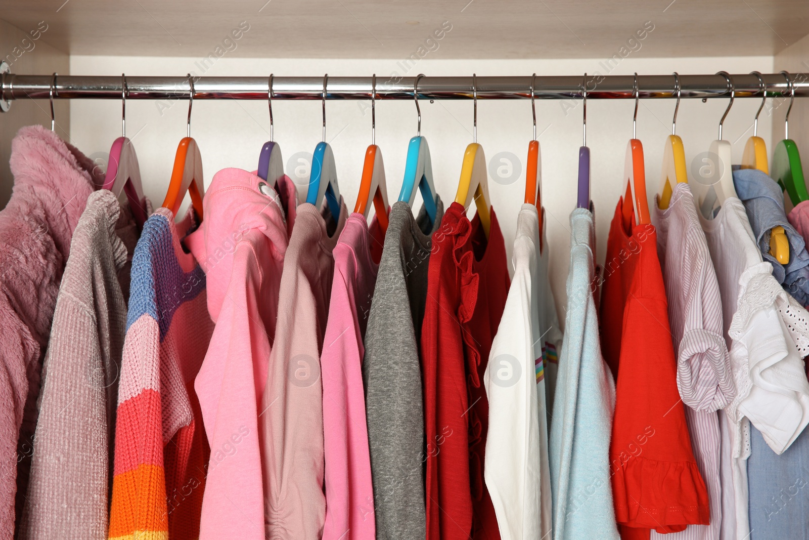 Photo of Wardrobe with stylish girl's clothes hanging on rack