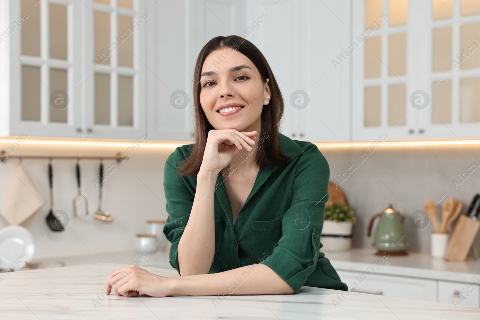 Photo of Portrait of beautiful young woman in kitchen