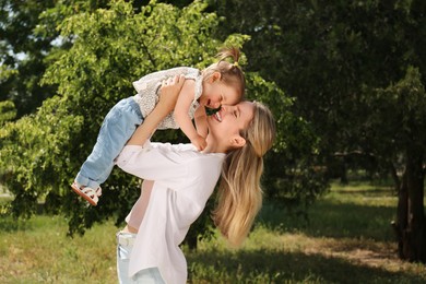 Happy mother with her daughter having fun in park