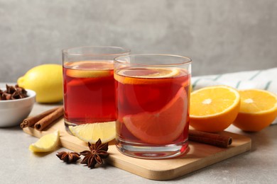 Photo of Aromatic punch drink and ingredients on grey table