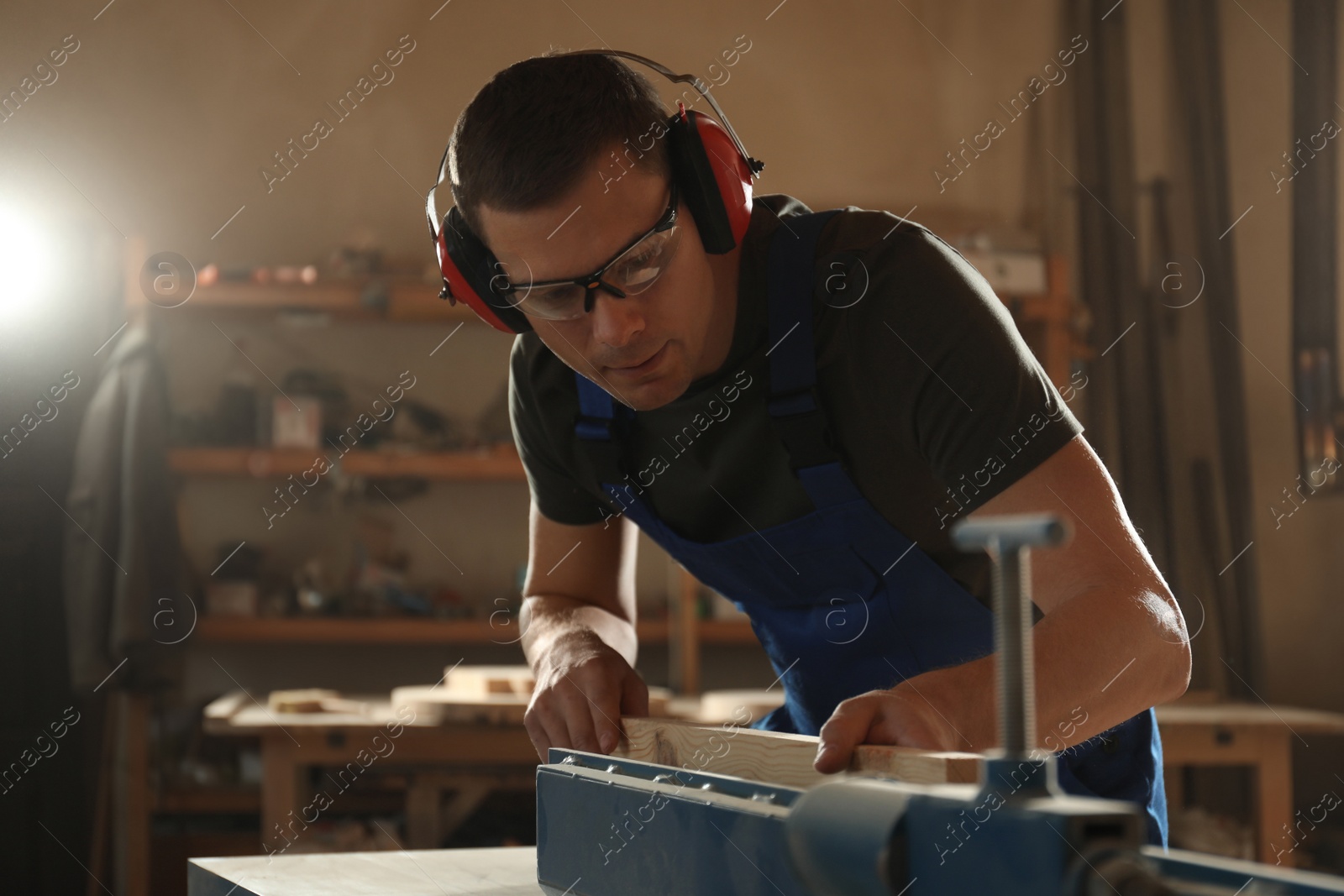 Photo of Professional carpenter working with wood in shop