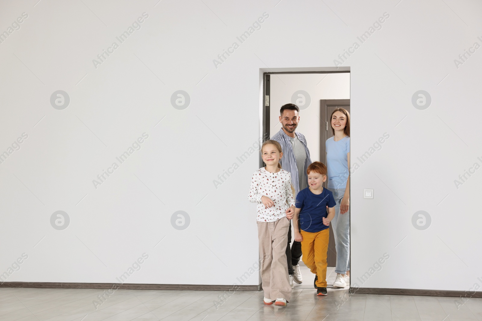 Photo of Happy family entering in their new apartment on moving day. Space for text